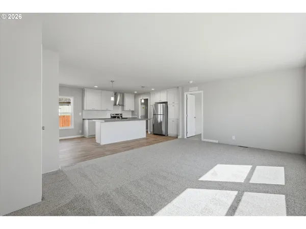 a view of kitchen with refrigerator and white cabinets