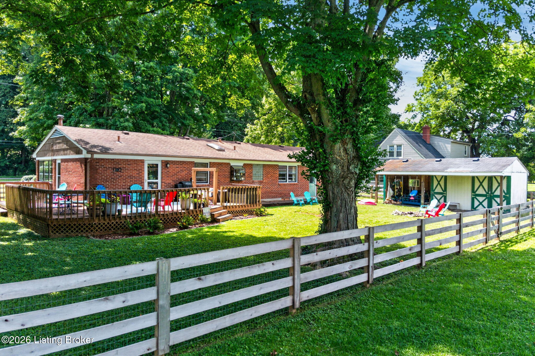 2104 North Rose Island Road Prospect, KY 40059 - Photo 55 of 57 A ground-level view captures the deck, barn, and fully fenced backyard framed by mature shade trees