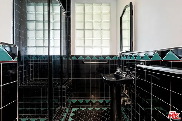 a bathroom with a black white checkered floor and a sink
