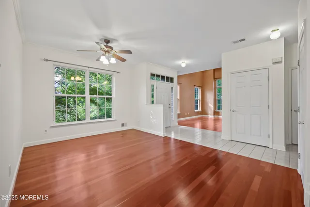 a view of an empty room with a fireplace and wooden floor