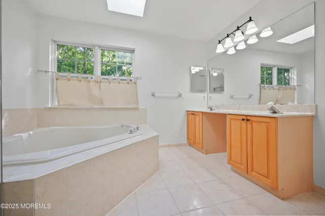 an empty room with windows and chandelier fan