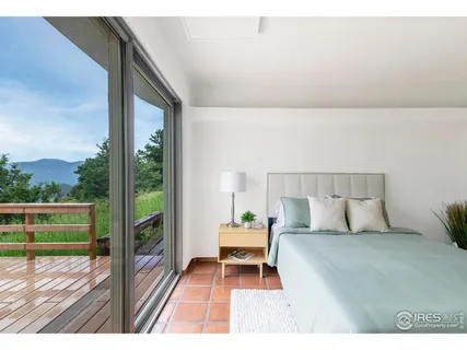 a bedroom with a bed table and a lamp