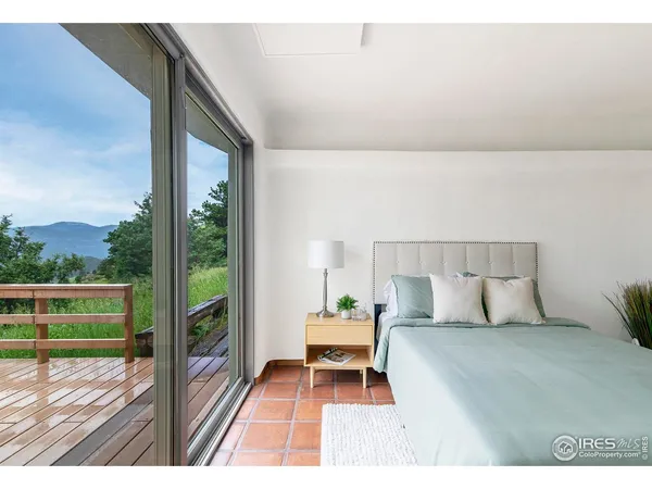 a bedroom with a bed table and a lamp