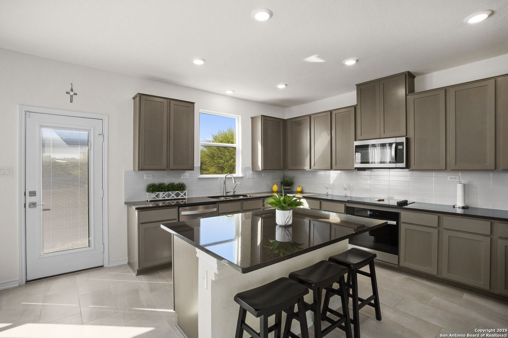 14839 Vance Jackson Road, Unit 508 San Antonio, TX 78249 - Photo 10 of 35 a kitchen with stainless steel appliances granite countertop a stove top oven a refrigerator a sink and a dining table with garden view