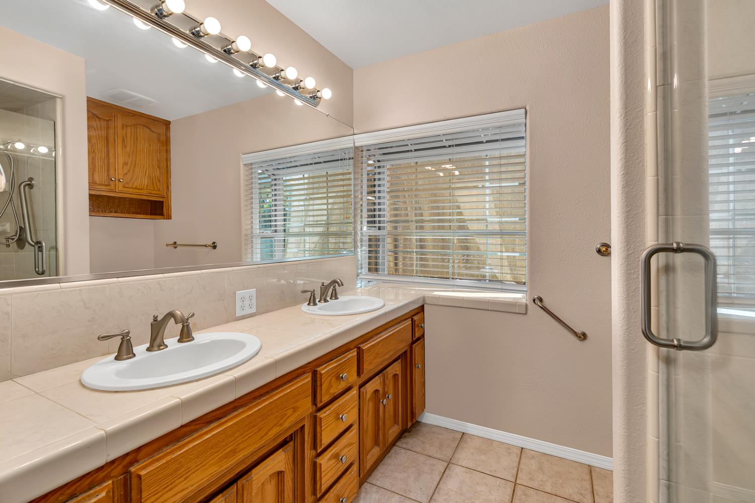 2352 Frederick Way Madera, CA 93637 - Photo 23 of 39 a bathroom with double vanity sink a mirror and shower