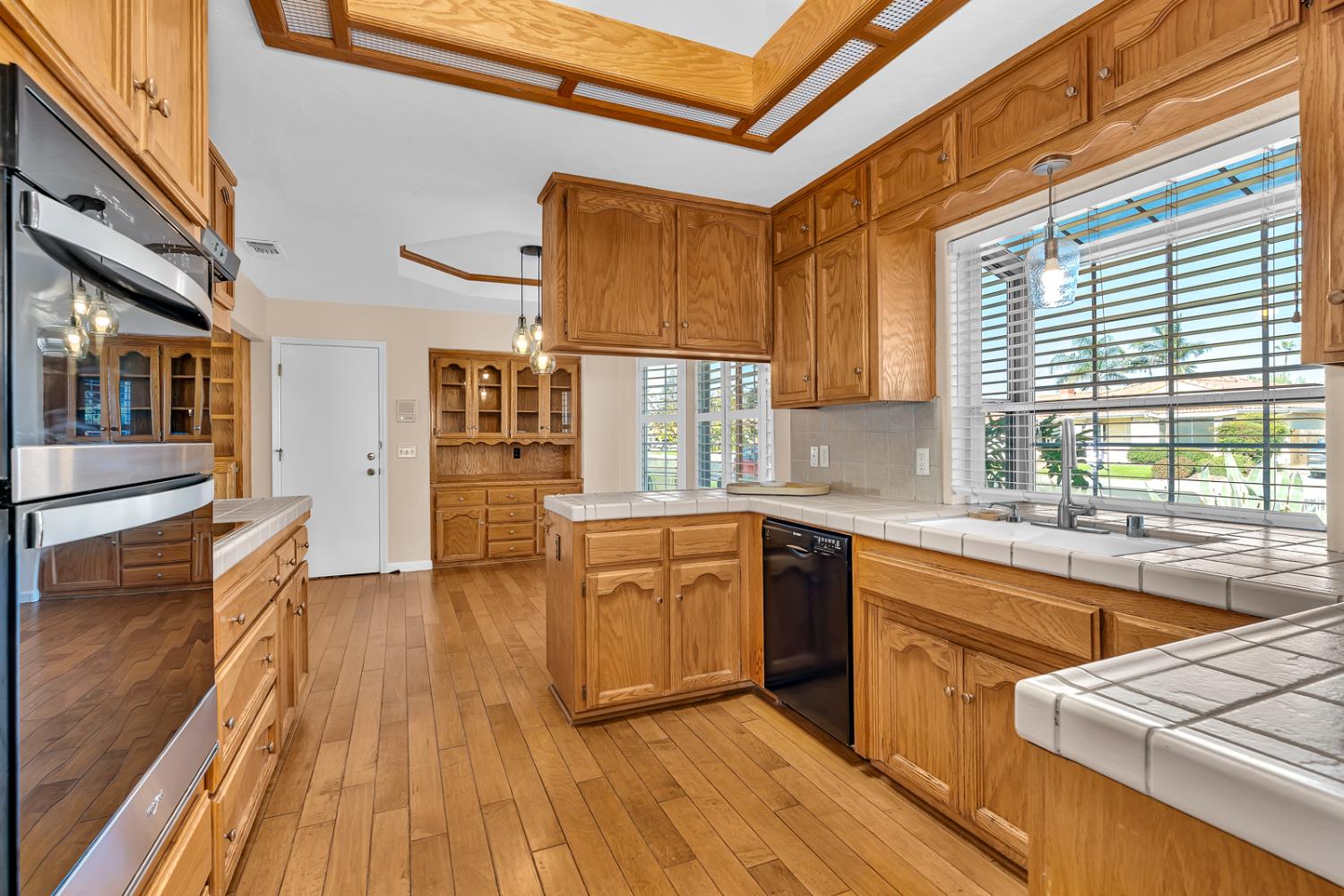 2352 Frederick Way Madera, CA 93637 - Photo 29 of 39 a kitchen with stainless steel appliances granite countertop wooden floors and white cabinets