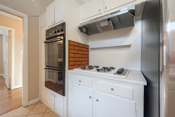 a kitchen with white cabinets and appliances