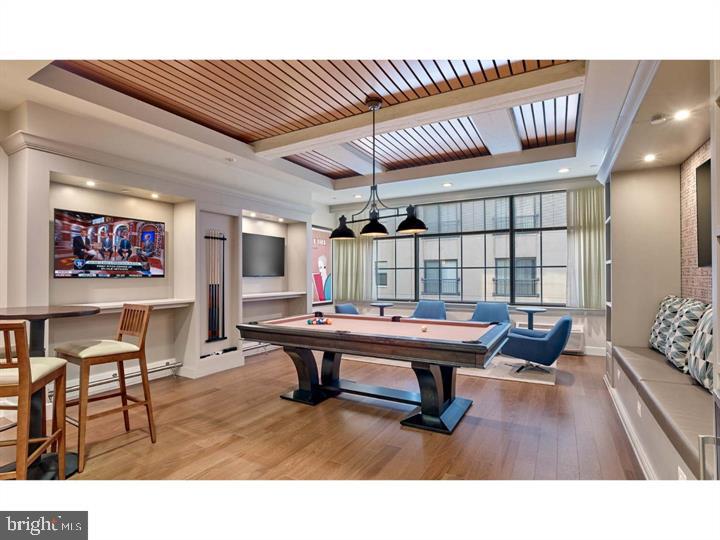 a living room with furniture pool table and flat screen tv