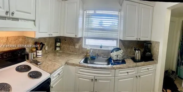 a kitchen with a stove a sink and a cabinets