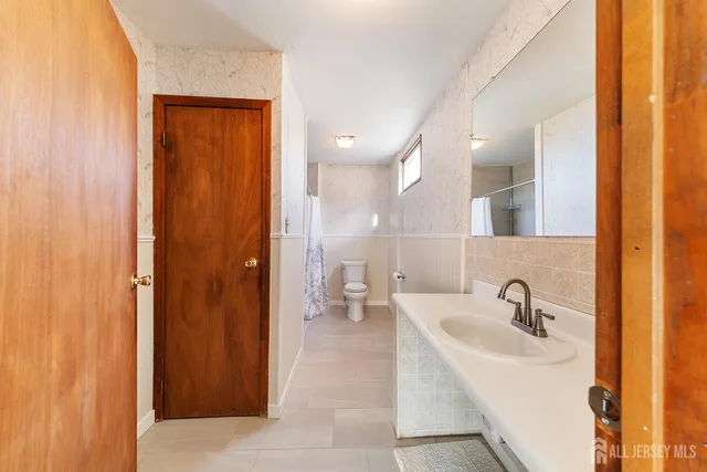a bathroom with a sink a toilet and shower