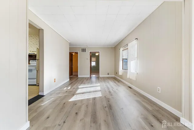 a view of an empty room with wooden floor