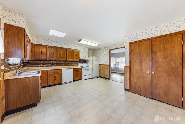a kitchen with stainless steel appliances granite countertop a stove refrigerator sink and cabinets
