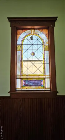 a view of empty room with wooden floor and a window