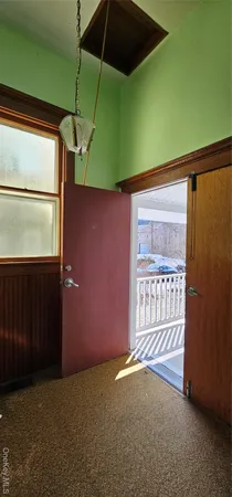 a view of an empty room with a fan and a window