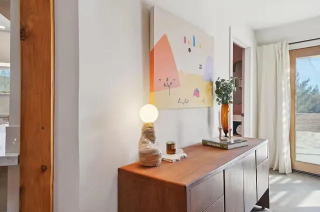 a front view of a house with garden and trees