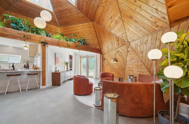 a living room with couches chair and kitchen view