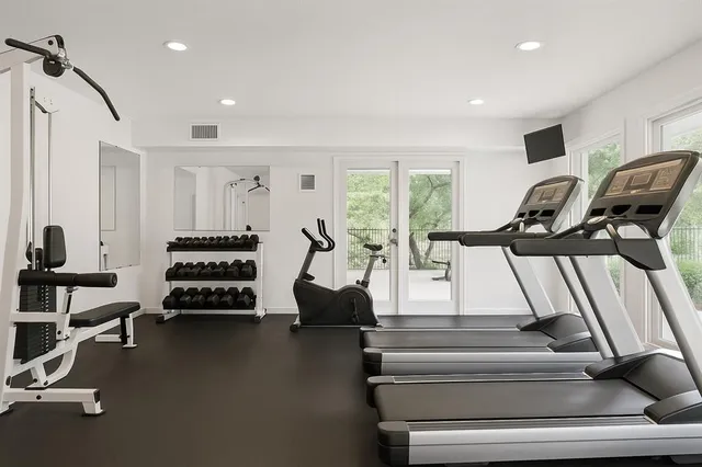 a view of swimming pool with lawn chairs and plants