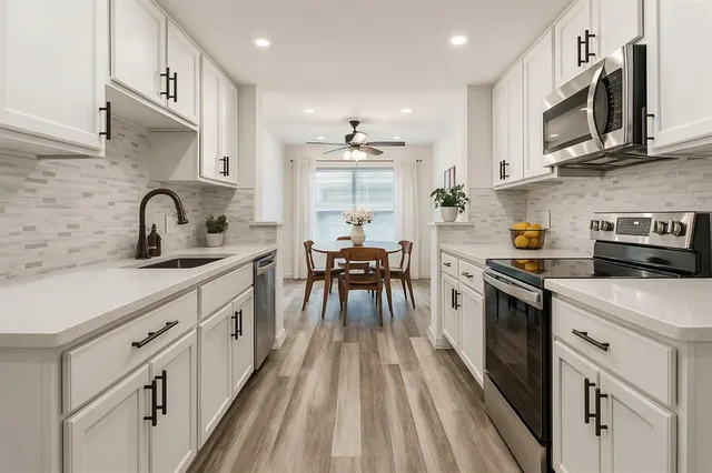 a kitchen with stainless steel appliances granite countertop a stove a sink dishwasher and a microwave oven with wooden cabinets
