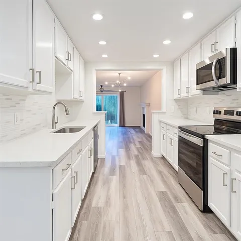 a large kitchen with stainless steel appliances granite countertop a lot of counter space and wooden floor