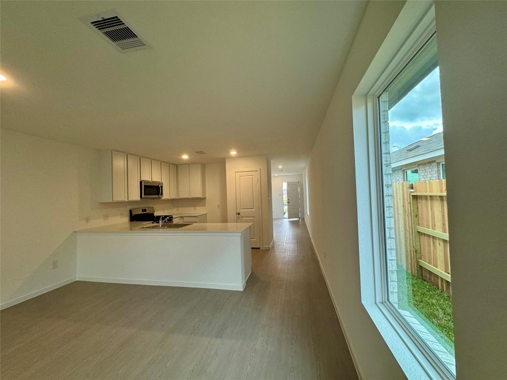 26710 Feather Reed Drive Katy, TX 77493 - Photo 4 of 10 a view of a kitchen with kitchen island stainless steel appliances wooden floor and window