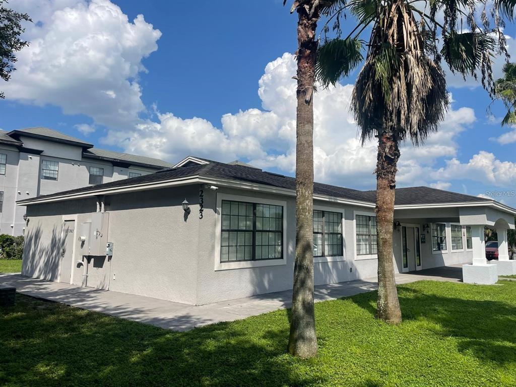 2323 McCoy Road, Unit 701 Orlando, FL 32809 - Photo 2 of 11 a front view of a house with a yard and potted plants
