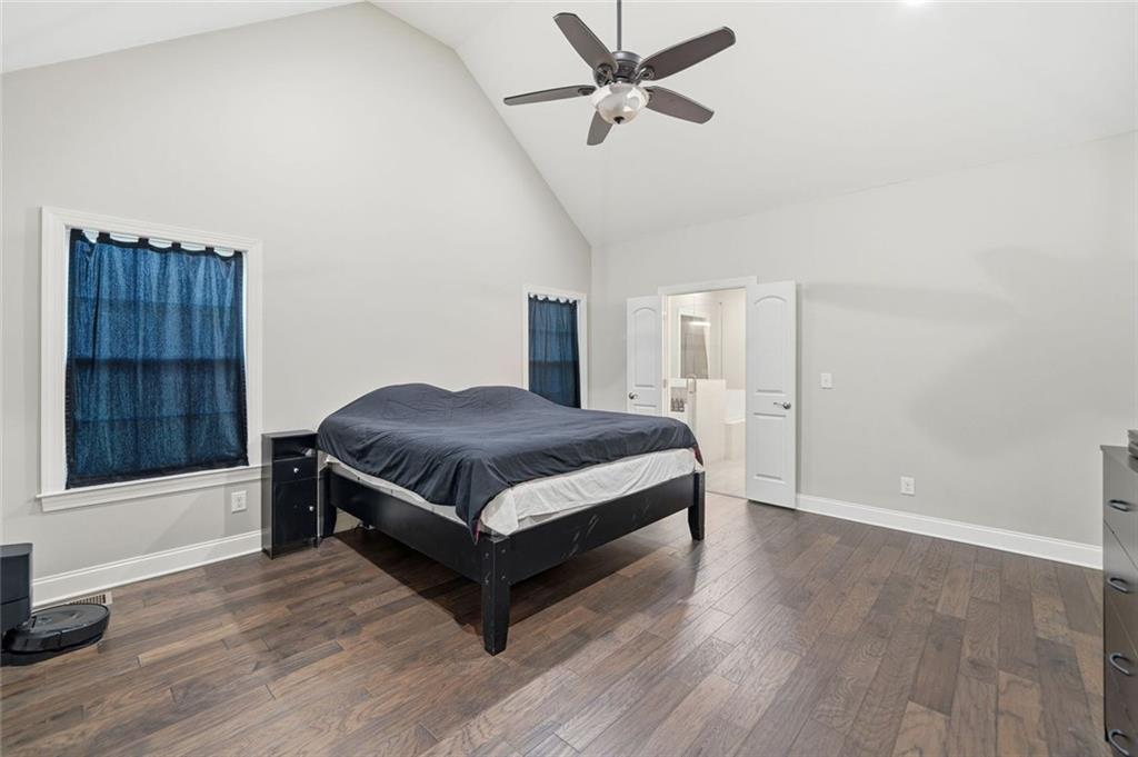 1006 Owens Store Road Canton, GA 30115 - Photo 19 of 48 a spacious bedroom with a bed and a chandelier