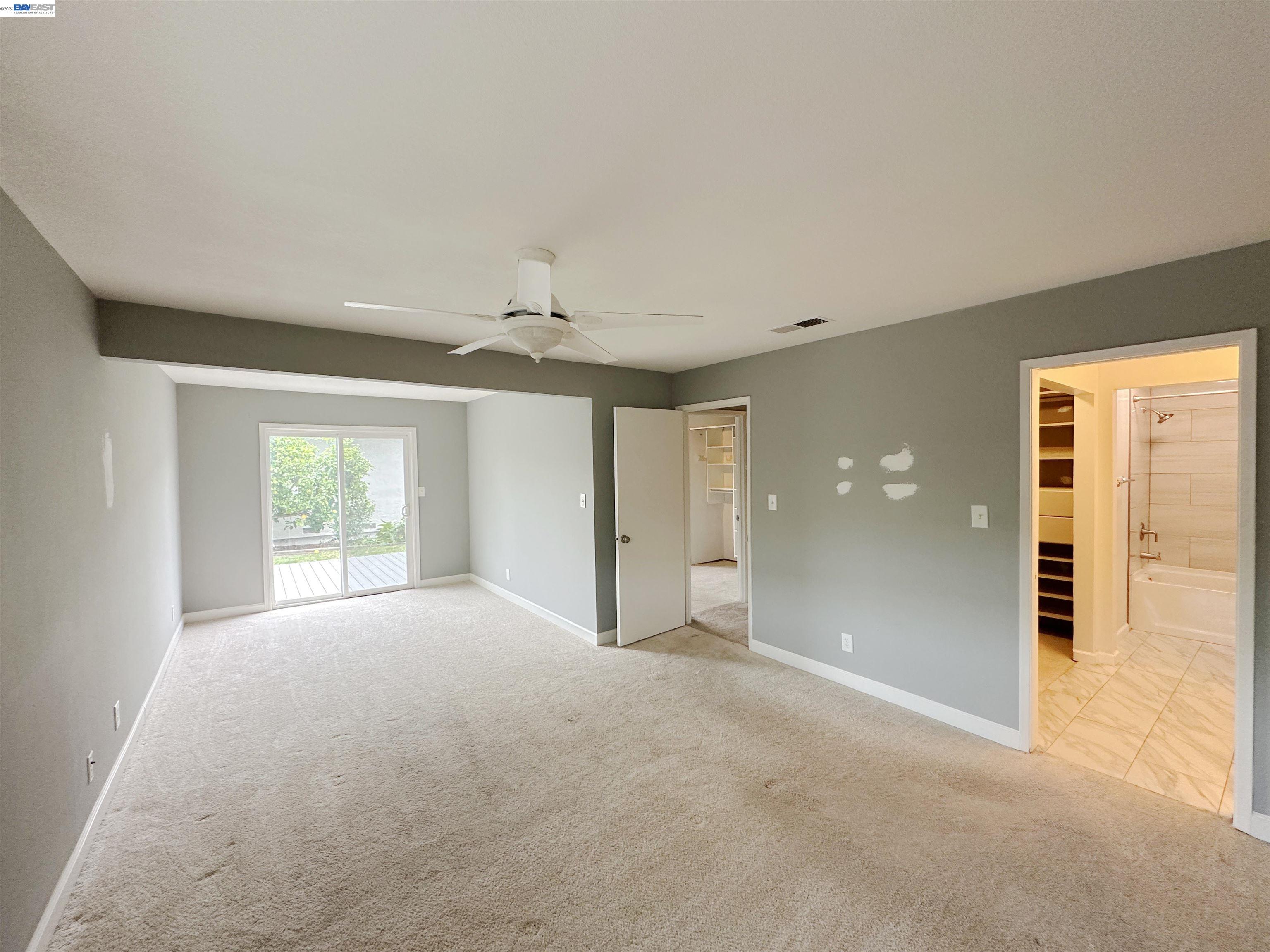 4565 Wildcat Lane Concord, CA 94521 - Photo 11 of 15 an empty room with windows and a chandelier fan