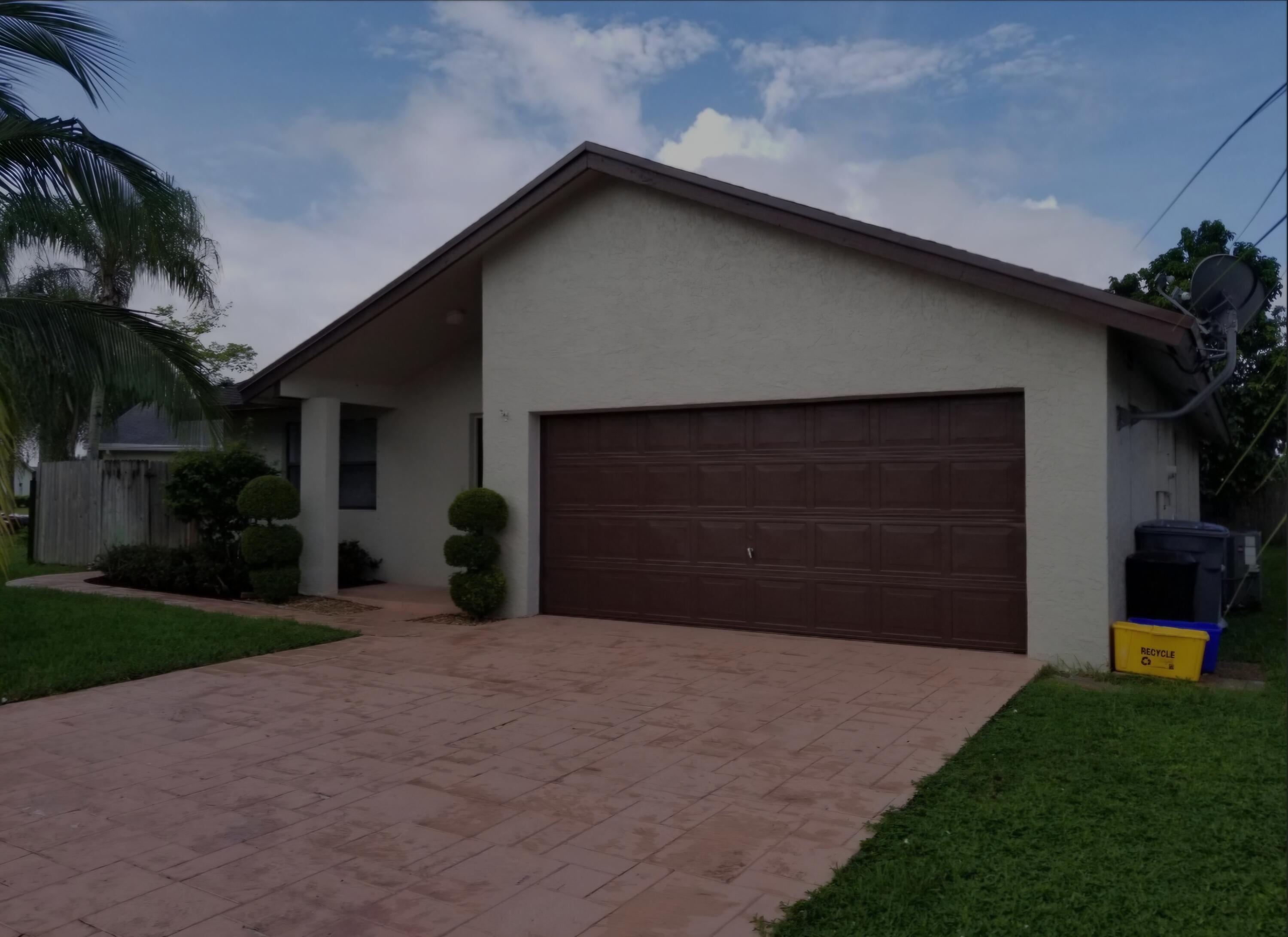 22761 Southwest 64th Way Boca Raton, FL 33428 - Photo 2 of 22 a front view of a house with a yard and garage