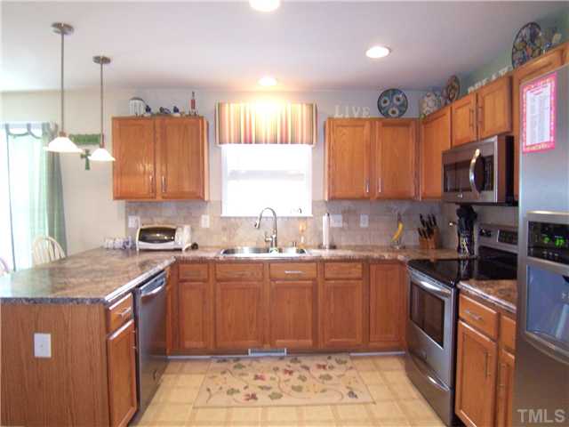 2115 Summer Shire Way Raleigh, NC 27604 - Photo 5 of 25 UPDATED Kitchen features granite-look WilsonArt HD laminate ctrs w/ogee edge, SS appls (smooth-top range, MW, DW), stone tile backsplash, recessed & pendant lights, SS offset dbl sink & gooseneck faucet, desk and walk-in Pantry!