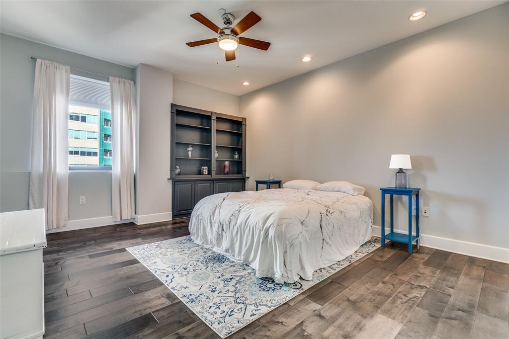 1505 Elm Street, Unit 1504 Dallas, TX 75201 - Photo 21 of 33 a bed sitting in a spacious bedroom next to a window and a chandelier