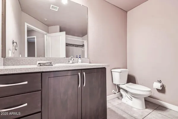 a bathroom with a granite countertop toilet sink and mirror