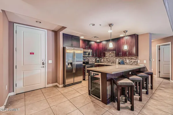 a kitchen with kitchen island granite countertop a sink and refrigerator