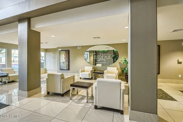 a living room with couches and a dining table with painted walls