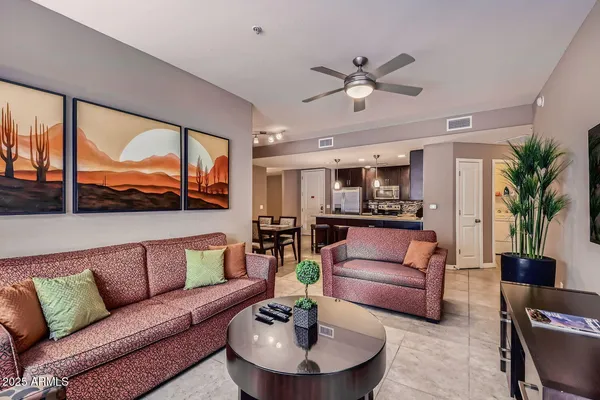 a living room with furniture ceiling fan and a large window