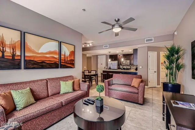 a living room with furniture ceiling fan and a large window