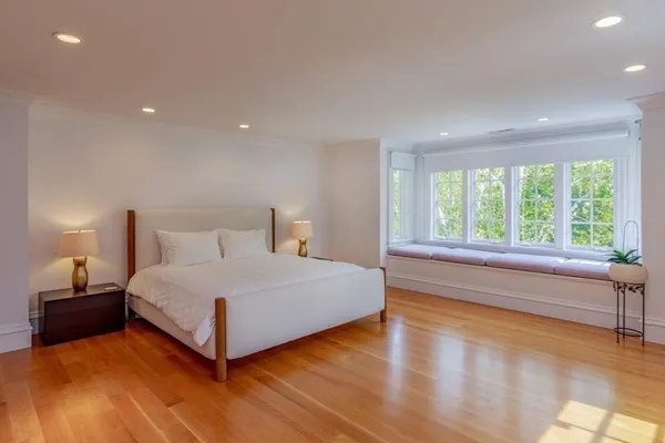 a bedroom with a bed and a large window