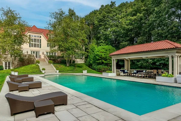 a view of a house with swimming pool and sitting area