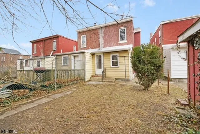 a view of a house with a small yard and wooden fence