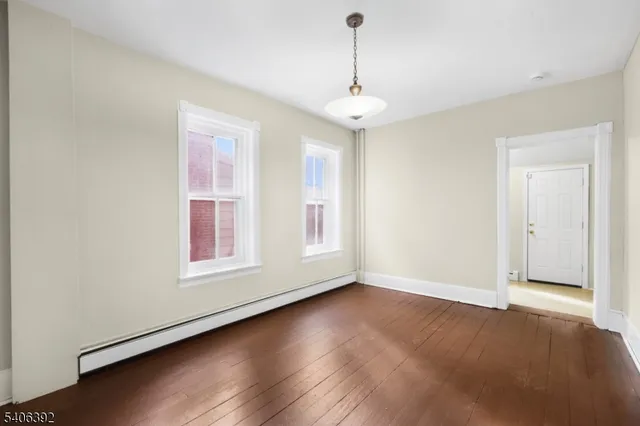 a view of an empty room with chandelier and window