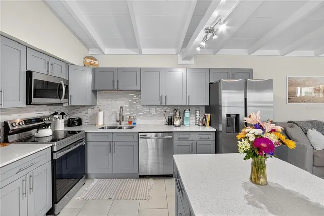 a kitchen with granite countertop a sink stainless steel appliances and cabinets