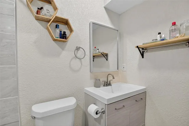 a bathroom with a toilet sink and mirror