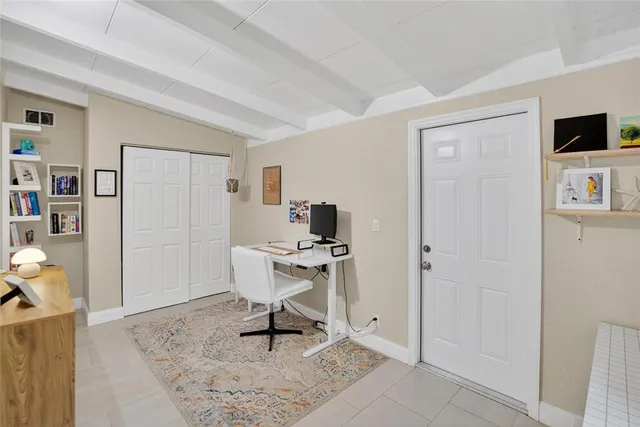 a work room with furniture a flat screen tv and a window
