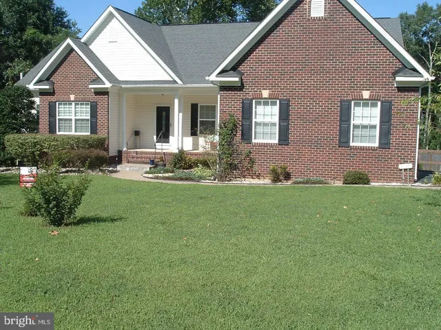 a front view of a house with a garden and plants