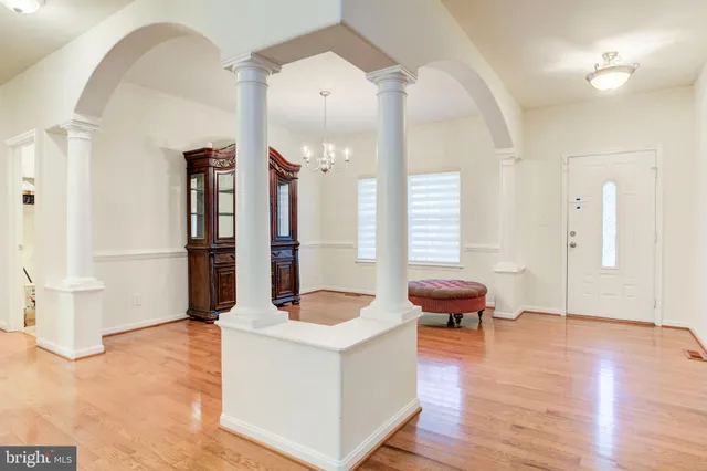a living room with furniture or chandelier and a wooden floor