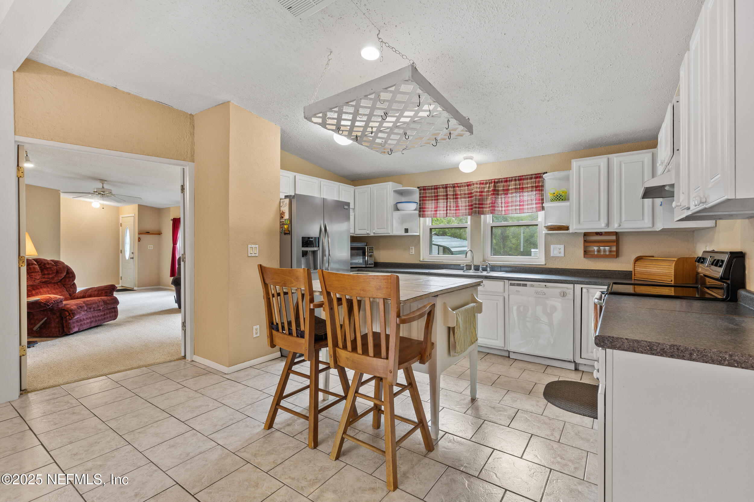 5671 Chugah Street Keystone Heights, FL 32656 - Photo 19 of 47 a kitchen with stainless steel appliances granite countertop a sink a stove a refrigerator cabinets and chairs
