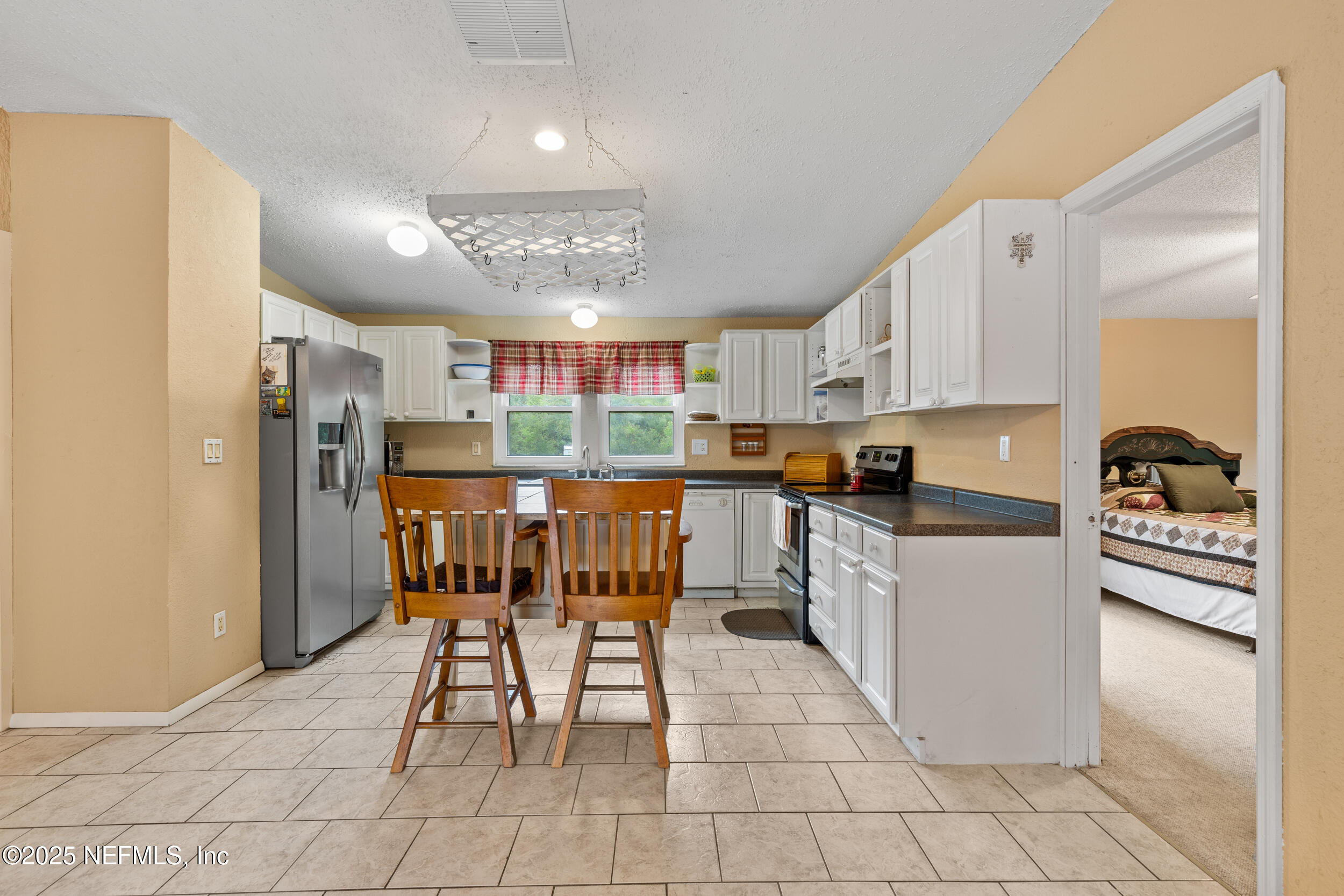5671 Chugah Street Keystone Heights, FL 32656 - Photo 20 of 47 a kitchen with stainless steel appliances kitchen island granite countertop a refrigerator and a stove top oven