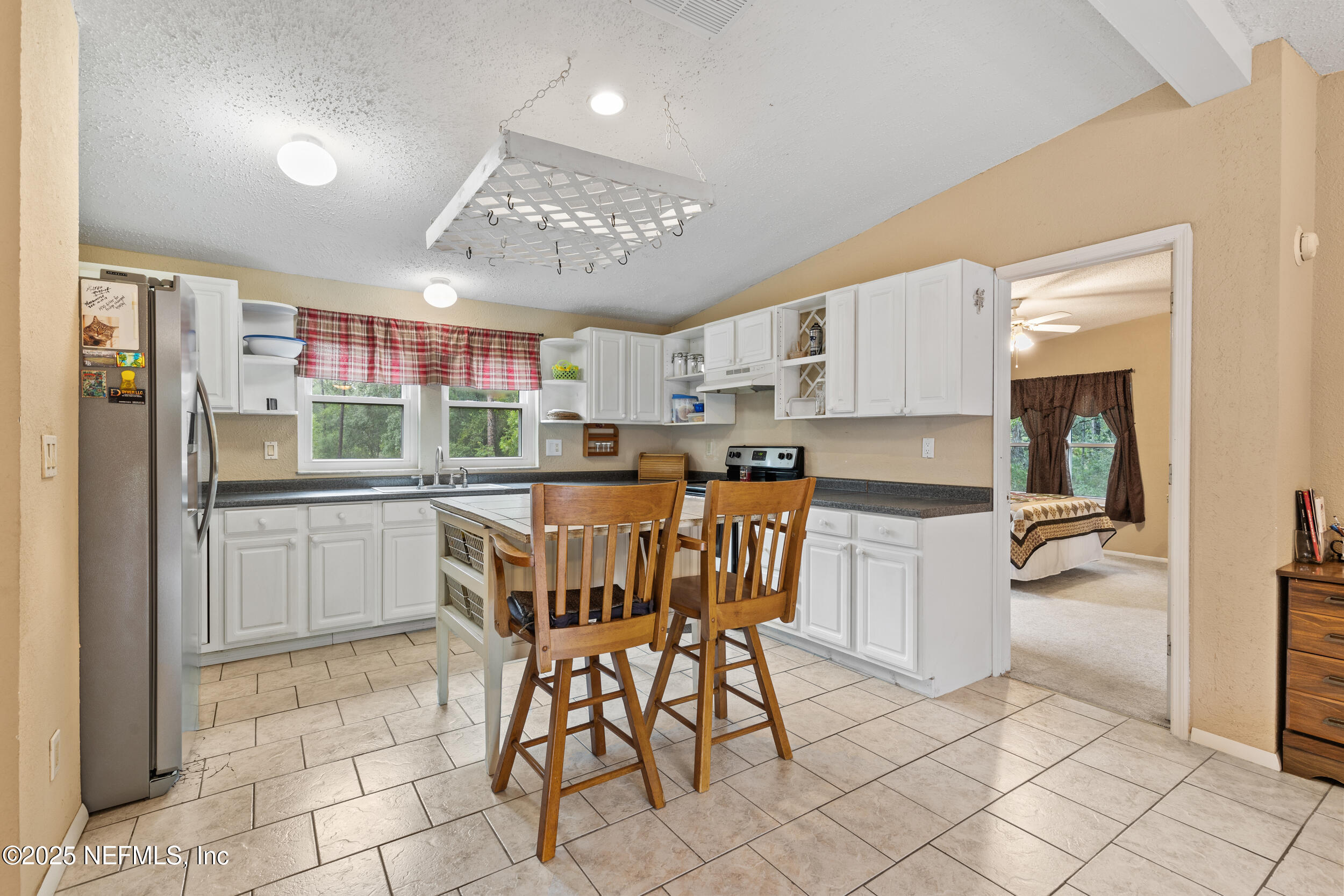 5671 Chugah Street Keystone Heights, FL 32656 - Photo 21 of 47 a kitchen with kitchen island a counter top space a sink cabinets and stainless steel appliances