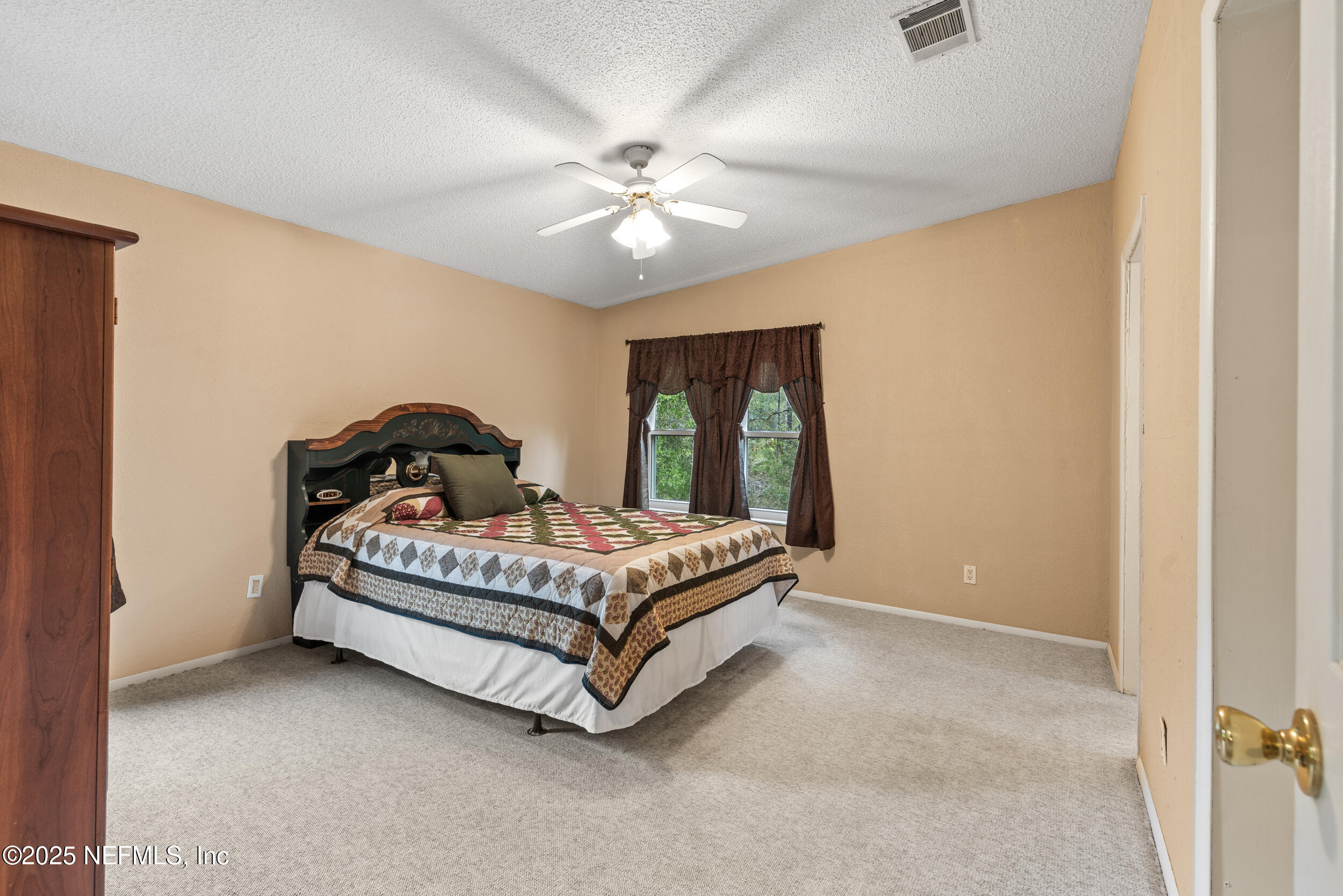 5671 Chugah Street Keystone Heights, FL 32656 - Photo 27 of 47 a bedroom with a bed and a ceiling fan