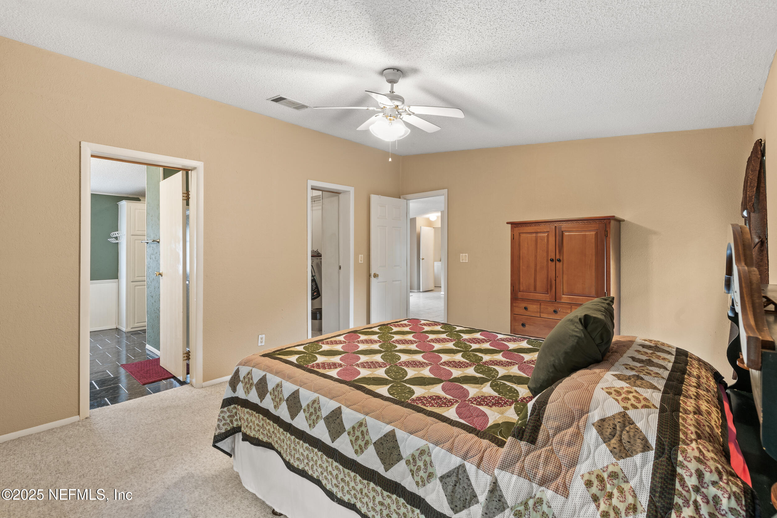 5671 Chugah Street Keystone Heights, FL 32656 - Photo 28 of 47 a bedroom with a large bed and a chandelier
