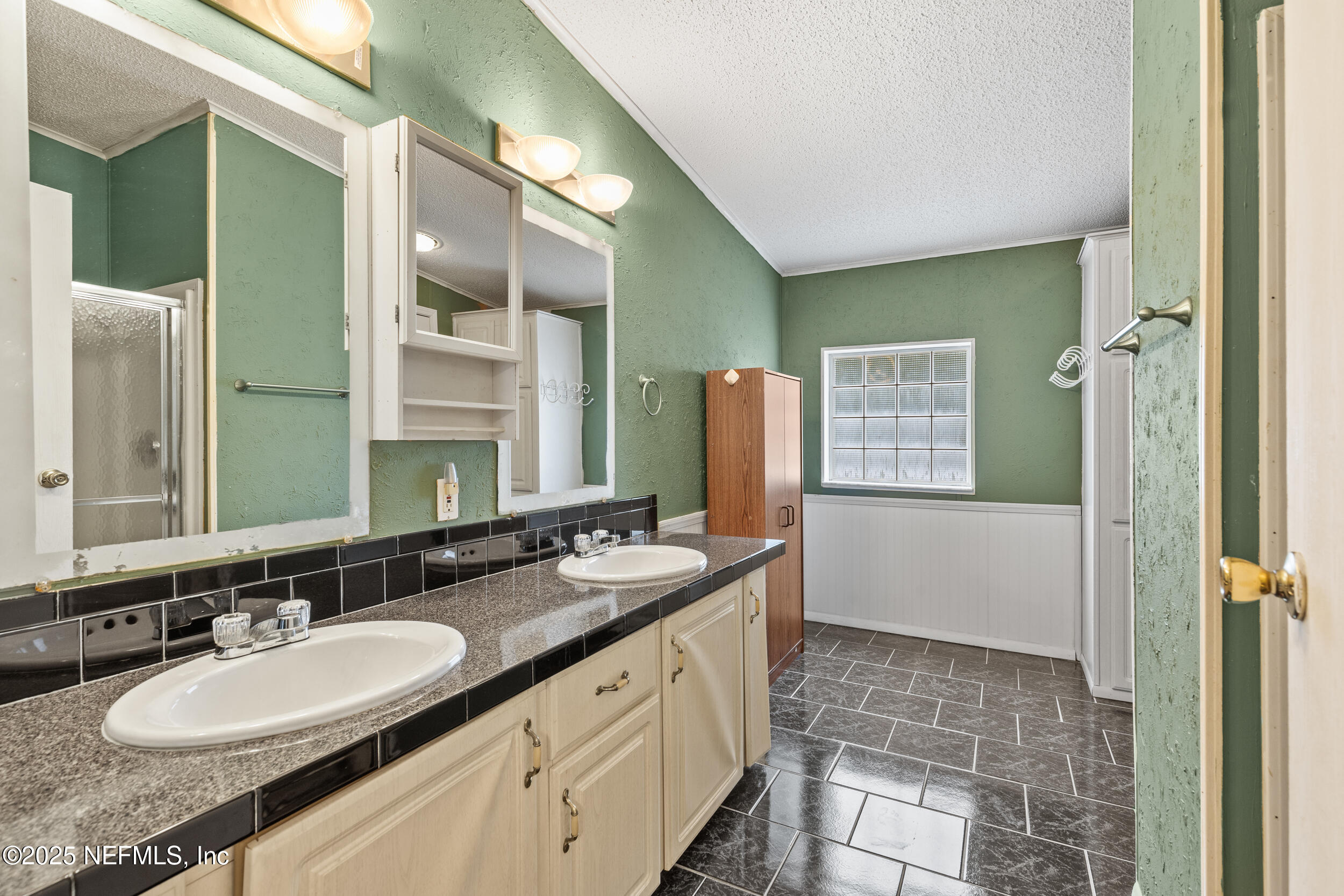 5671 Chugah Street Keystone Heights, FL 32656 - Photo 29 of 47 a bathroom with a double vanity sink a mirror and a bathtub